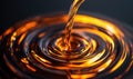 A cascade of rich amber liquid creates mesmerizing ripples on a dark, reflective surface. Royalty Free Stock Photo