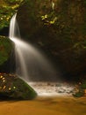 Cascade on small mountain stream, water is running over mossy sandstone boulders and bubbles create on level milky water. Royalty Free Stock Photo