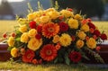 Cascade-Style Bouquet in Red, Orange, and Yellow Adorning a Grave with Heartfelt Beauty.