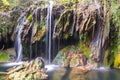 the cascade is surrounded by mossy rocks and water from its pools