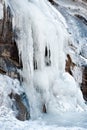 Cascade of water frozen in the vertical wall of the mountain