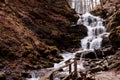 Cascading down a small mountain stream, the water runs over basalt boulders. A small waterfall runs through the moss. Royalty Free Stock Photo