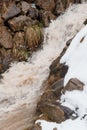 Cascading Mountain Stream Surrounded by Snow and Rocks Royalty Free Stock Photo