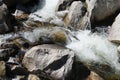 a stream of water running down rocks near waterline at bottom of waterfall