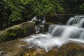 Cascading tropical waterfall. wet and mossy rock, surrounded by green rain forest Royalty Free Stock Photo