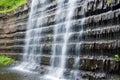 cascading water over layered rock wall