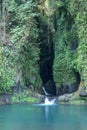 Cascading waterfall in narrow and dark rocky canyon. Blue lagoon on Bali island in Indonesia. Natural lake with blue water. Royalty Free Stock Photo