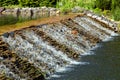 Cascading waterfall of stone in a decorative pond. Royalty Free Stock Photo