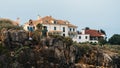 Young women take pictures next to a dangerous jagged cliff in Cascais, Portugal