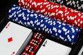 A case of betting chips in red, blue and black alongside 2 standard decks of cards showing an Ace of Diamonds and of Clubs with a Royalty Free Stock Photo