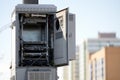 The case of the cellular base station unit with an open door on the background of high-rise buildings. Selective focus. Copy space Royalty Free Stock Photo