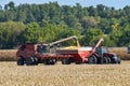 Case 8120 combine unloading corn into a Killbros grain wagon being pulled by a Case 305 tractor