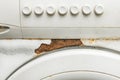 The case or front of an old white washing machine close-up with traces of rust and a button control panel Royalty Free Stock Photo