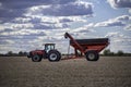 Case IH tractor and an Unverferth grain cart rest in a completely harvested field Royalty Free Stock Photo