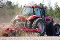 New Lisbon, Wisconsin USA - May 4th, 2022: Farmer driving a Case 305 Magnum tractor while pulling a plow to plow up a farming fiel