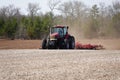 New Lisbon, Wisconsin USA - May 4th, 2022: Farmer driving a Case 305 Magnum tractor while pulling a plow to plow up a farming fiel