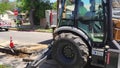 A CASE 590 Super N Backhoe Loader digs a trench with a worker in a construction vest and hardhat