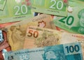 Cash bills from Canada and Brazil currency. Overhead view of bills of different amounts. Royalty Free Stock Photo