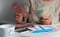 Cash bills from Canadian currency. Dollars. Old woman counting bills on table