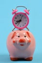 Cash box with financial income. Ceramic toy pig with stopwatch Royalty Free Stock Photo