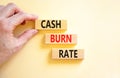 Cash burn rate symbol. Concept words Cash burn rate on wooden blocks on a beautiful white table white background. Businessman hand Royalty Free Stock Photo