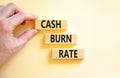 Cash burn rate symbol. Concept words Cash burn rate on wooden blocks on a beautiful white table white background. Businessman hand Royalty Free Stock Photo