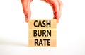 Cash burn rate symbol. Concept words Cash burn rate on wooden blocks on a beautiful white table white background. Businessman hand Royalty Free Stock Photo