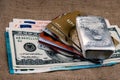 Cash dollars, euros, plastic cards and silver bullion against the background of coarse cloth. Royalty Free Stock Photo