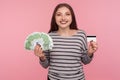 Cash and electronic money. Portrait of happy woman in striped sweatshirt holding euro bills and credit card Royalty Free Stock Photo