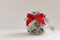 Cash euro banknotes in gift money box. Glass jar piggy bank, money and red bow. Cash reward, gift Background, copy space Royalty Free Stock Photo