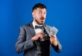 Cash transaction business. Easy cash loans. Man formal suit hold pile of dollar banknotes blue background. Businessman Royalty Free Stock Photo