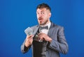 Cash transaction business. Easy cash loans. Man formal suit hold pile of dollar banknotes blue background. Businessman Royalty Free Stock Photo