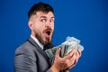 Cash transaction business. Man happy winner rich hold pile of dollar banknotes blue background. Easy cash loans Royalty Free Stock Photo