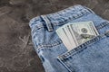 Cash in your pocket. Hundred dollar bills sticking out of the back pocket of blue jeans. Royalty Free Stock Photo