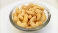 Cashew nuts without shell in a glass bowl, rotates, close up. Cashew nuts on white background from side. Close up