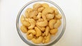 Cashew nuts on white background from overhead. Cashew nuts without shell in a glass bowl, rotates, close up