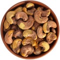 Cashews fried in shell in a brown ceramic bowl. Isolated close-up photo of food close up from above on white background Royalty Free Stock Photo