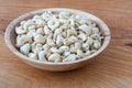 Cashews in a wooden bowl. Nuts are healthy food. Wooden background. Cashew kernel.