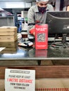 Cashier counter of pizza hut with warnings to maintain distance and QR code to access digital menu in the middle of the