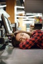 Cashier lady sleeping on workspace in supermarket shop. Royalty Free Stock Photo