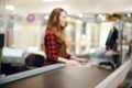 Cashier lady on workspace in supermarket shop. Focus on desk. Royalty Free Stock Photo