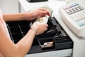 Cashier Searching For Change In Cash Register Drawer