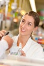 Cashier in supermarket taking credit card Royalty Free Stock Photo