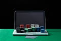 Casino chips and cards on keyboard notebook at green table. Royalty Free Stock Photo