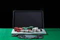 Casino chips and cards on keyboard notebook at green table. Royalty Free Stock Photo