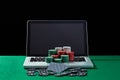 Casino chips and cards on keyboard notebook at green table. Royalty Free Stock Photo
