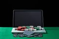 Casino chips and cards on keyboard notebook at green table. Royalty Free Stock Photo