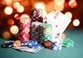 Casino chips and cards, two aces on the playing green table against bright bokeh lights. Poker game theme backdrop Royalty Free Stock Photo