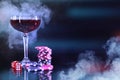 Casino chips, dice and glass of wine on dark background with smoke. Space for text Royalty Free Stock Photo