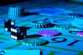 Casino chips with dice and playing cards on dark game table illuminated with blue light. Concept of gambling or poker Royalty Free Stock Photo